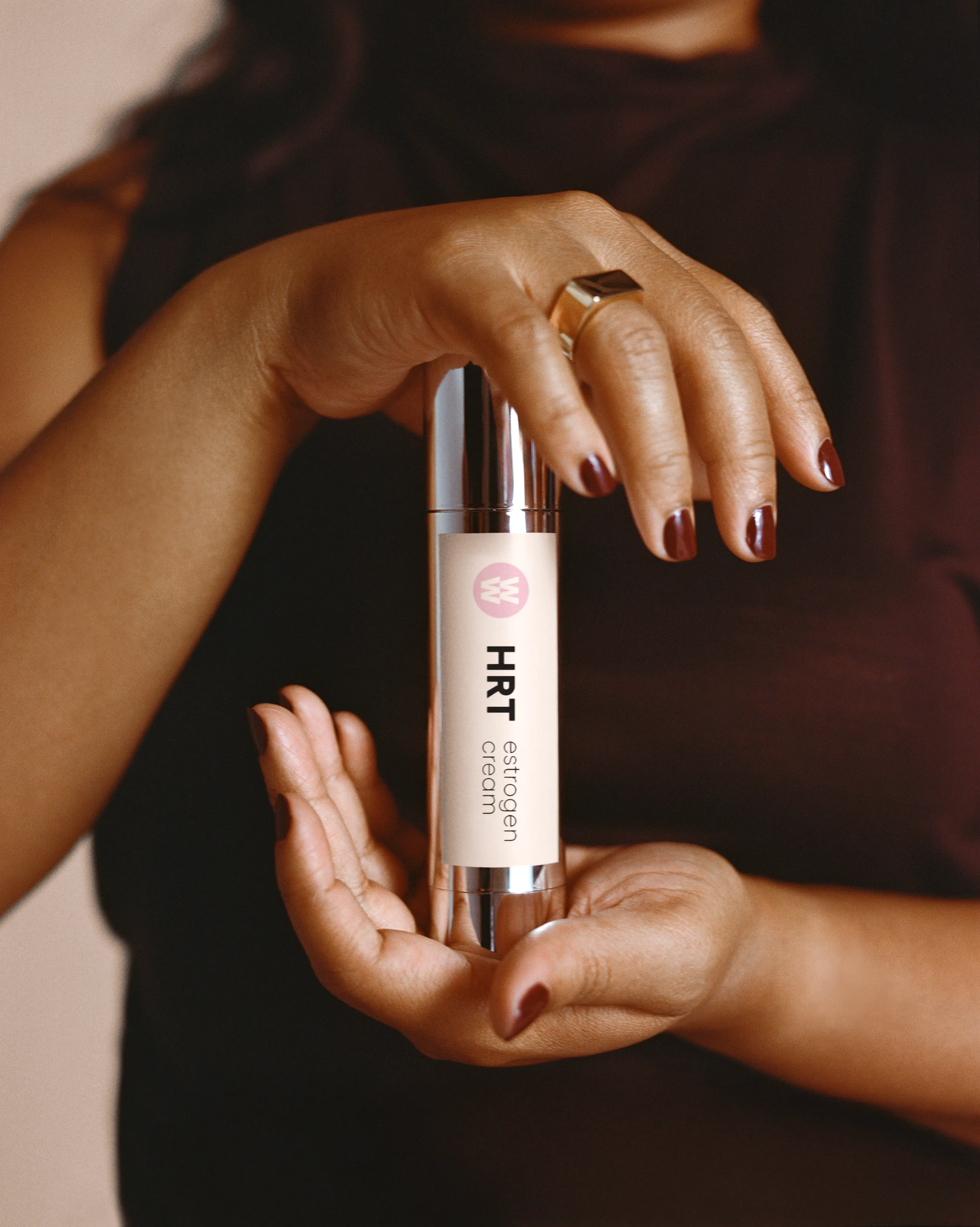 Close-up of a woman holding HRT estrogen cream for menopause symptom relief.
